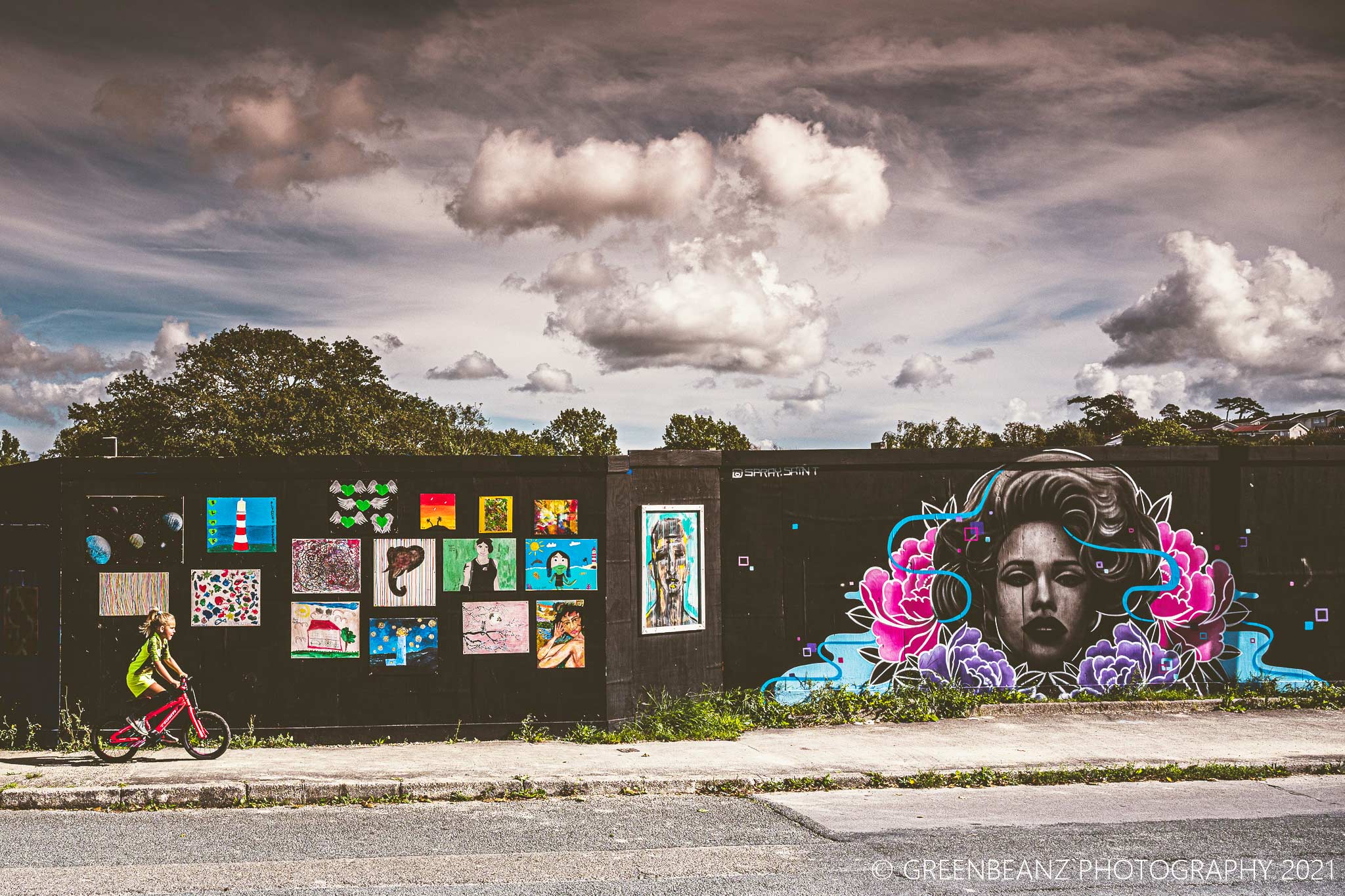 Girl riding bycycle in front of graffit and street art in Plymouth 2021