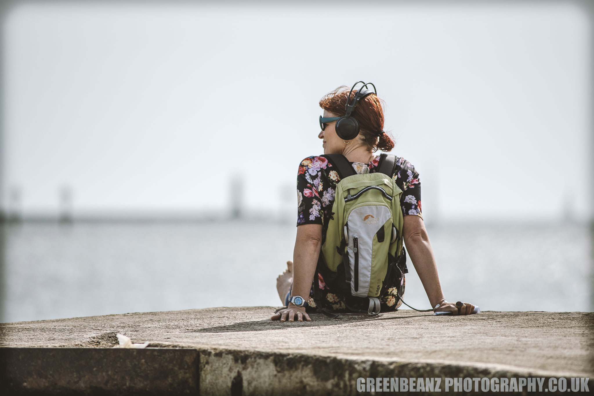 A listener absorbs the sounds of Laura Denning's Benthic Caress on the Plymouth Coast