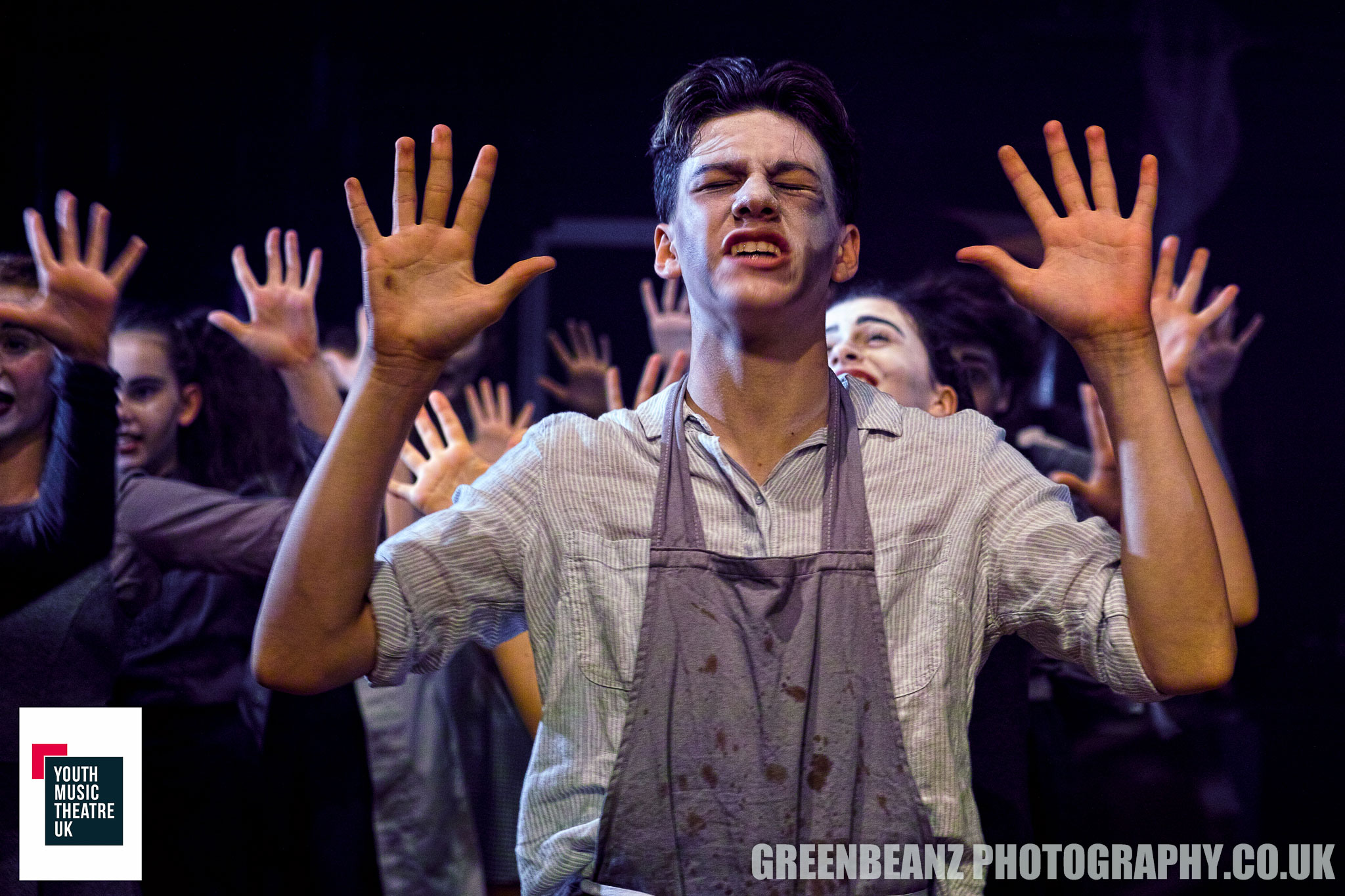 Performers with hands up in musical