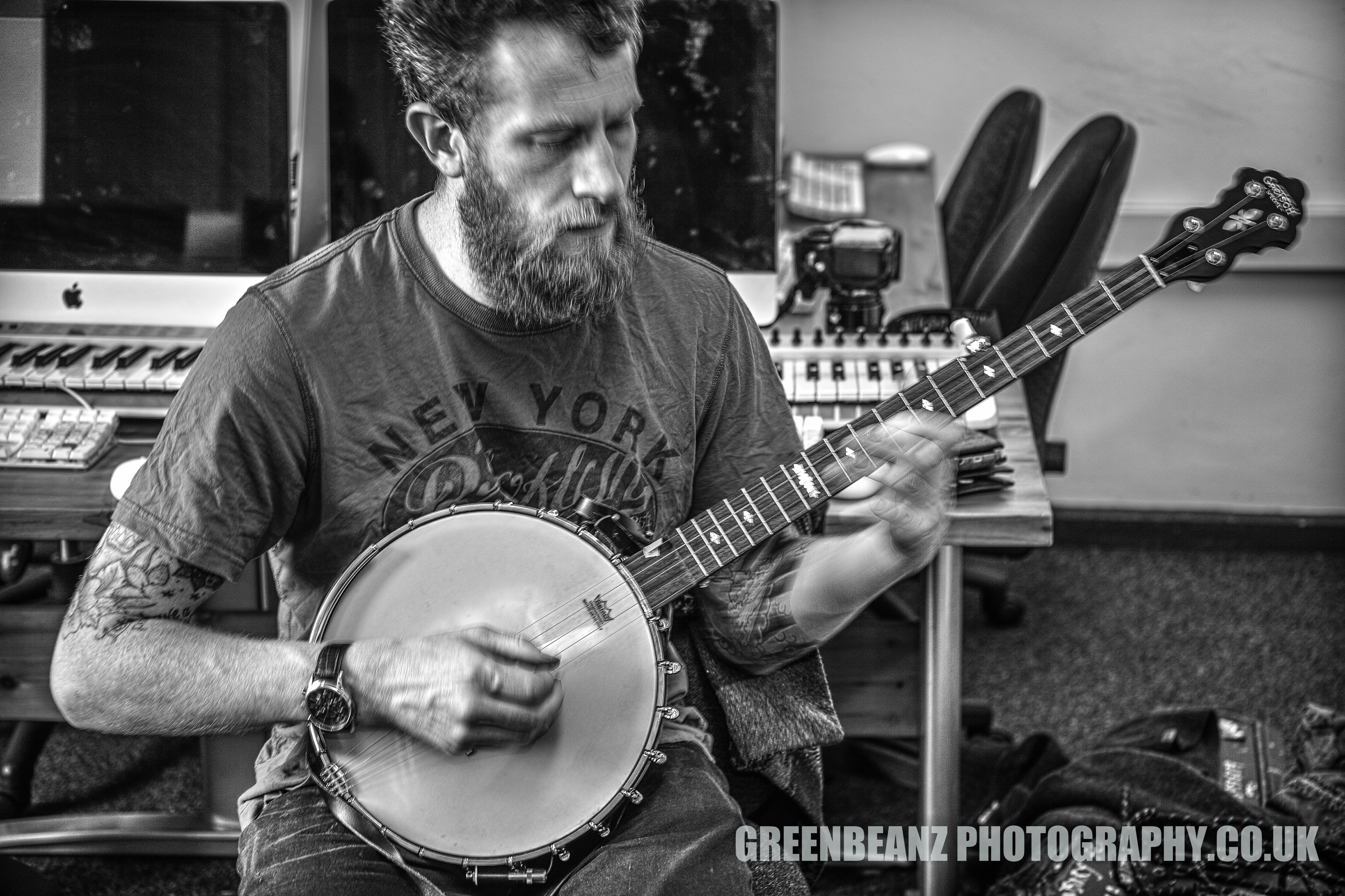 Seated Banjo Player photgraphed slow shutter speed hand held by Plymouth Photographer in black and White