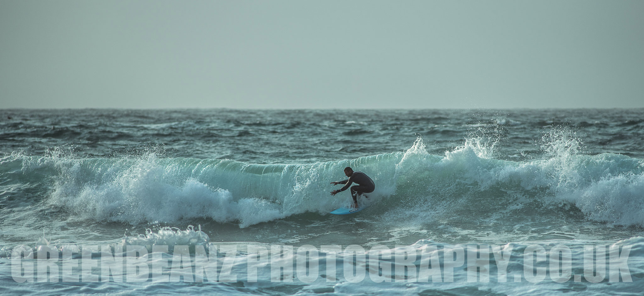 Surfer rides a wave of a messy sea in September at Newquay