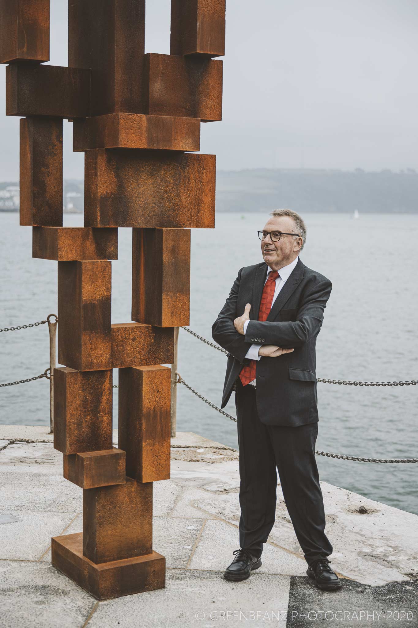 Tudor Evans stands next to Antony Gormleys sculpture in Plymouth