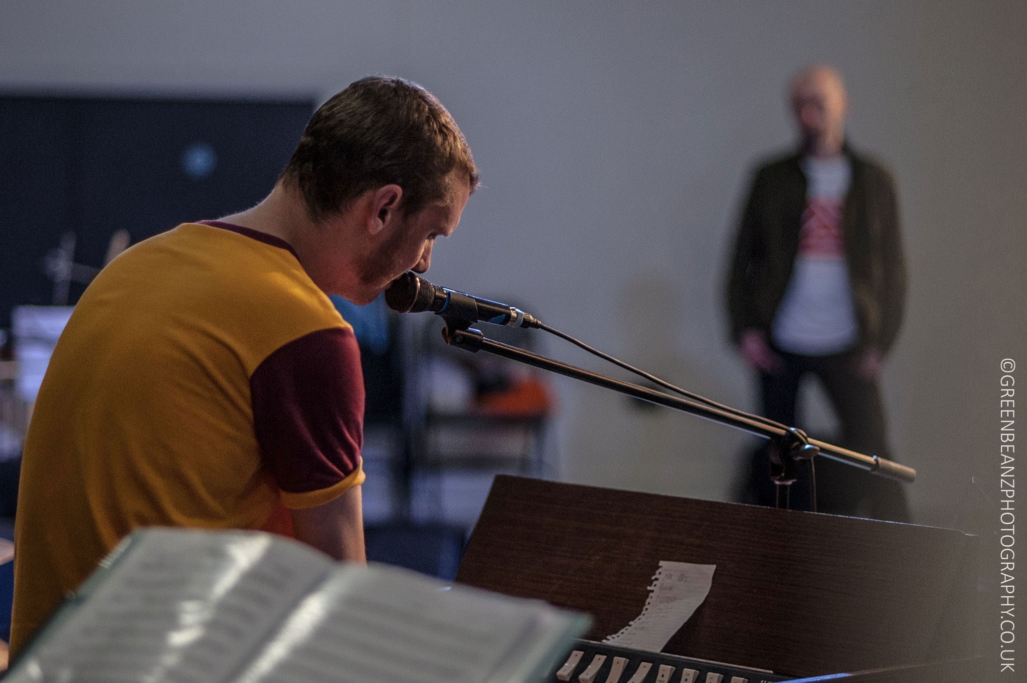 Harmonium player with man in background